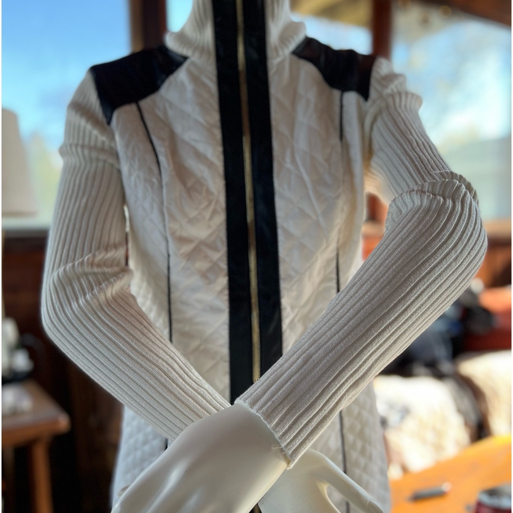 A stunning woman’s black & white zip up sweater with faux leather